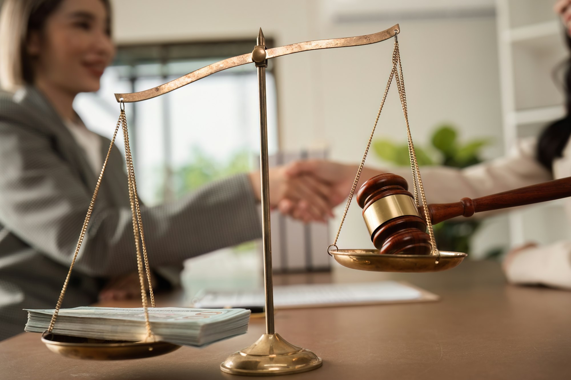 Lawyer and businesswoman shaking hands and reaching an agreement, legal corruption by bribing the